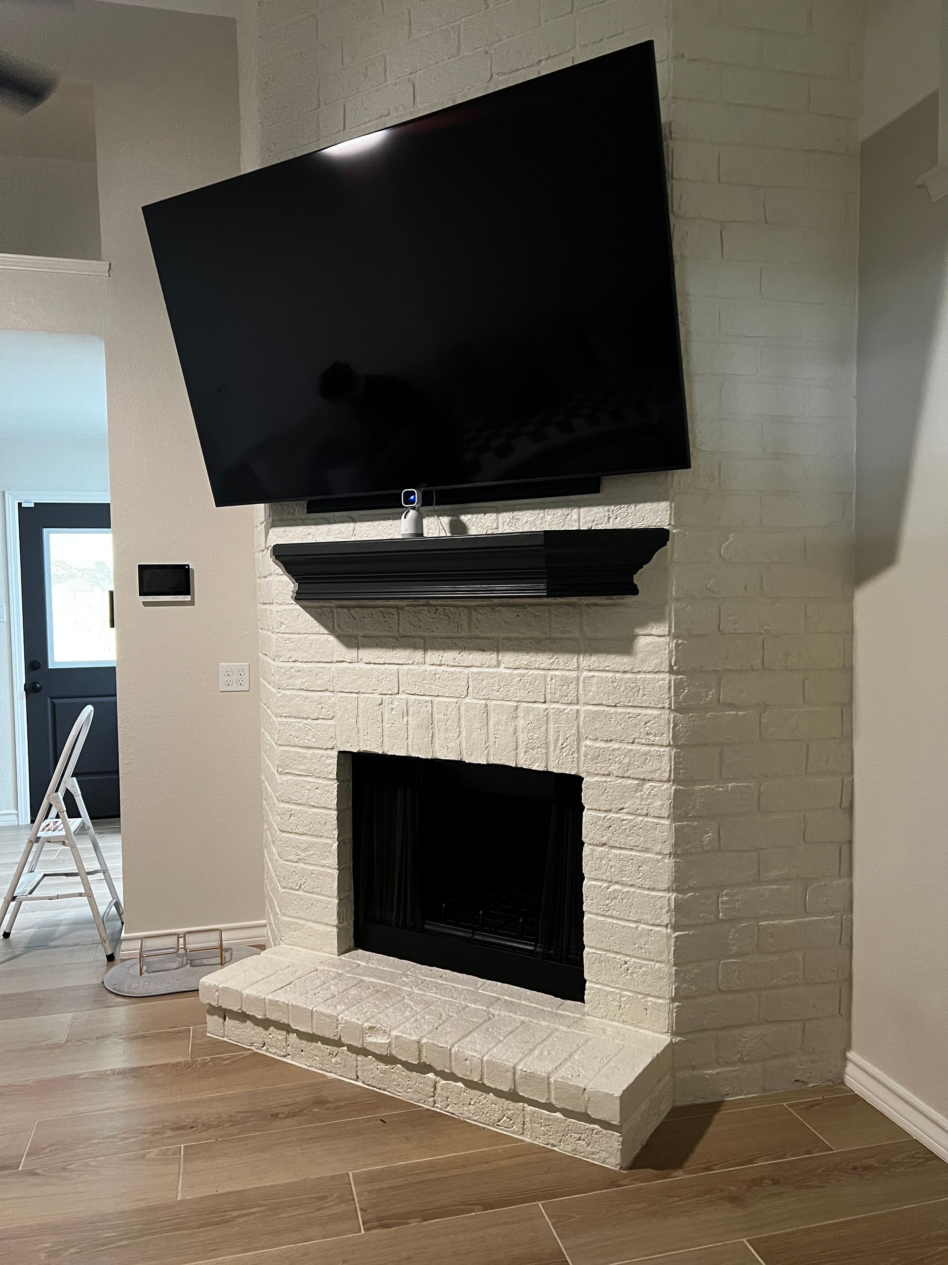 A living room with a fireplace and a flat screen tv mounted on the wall.