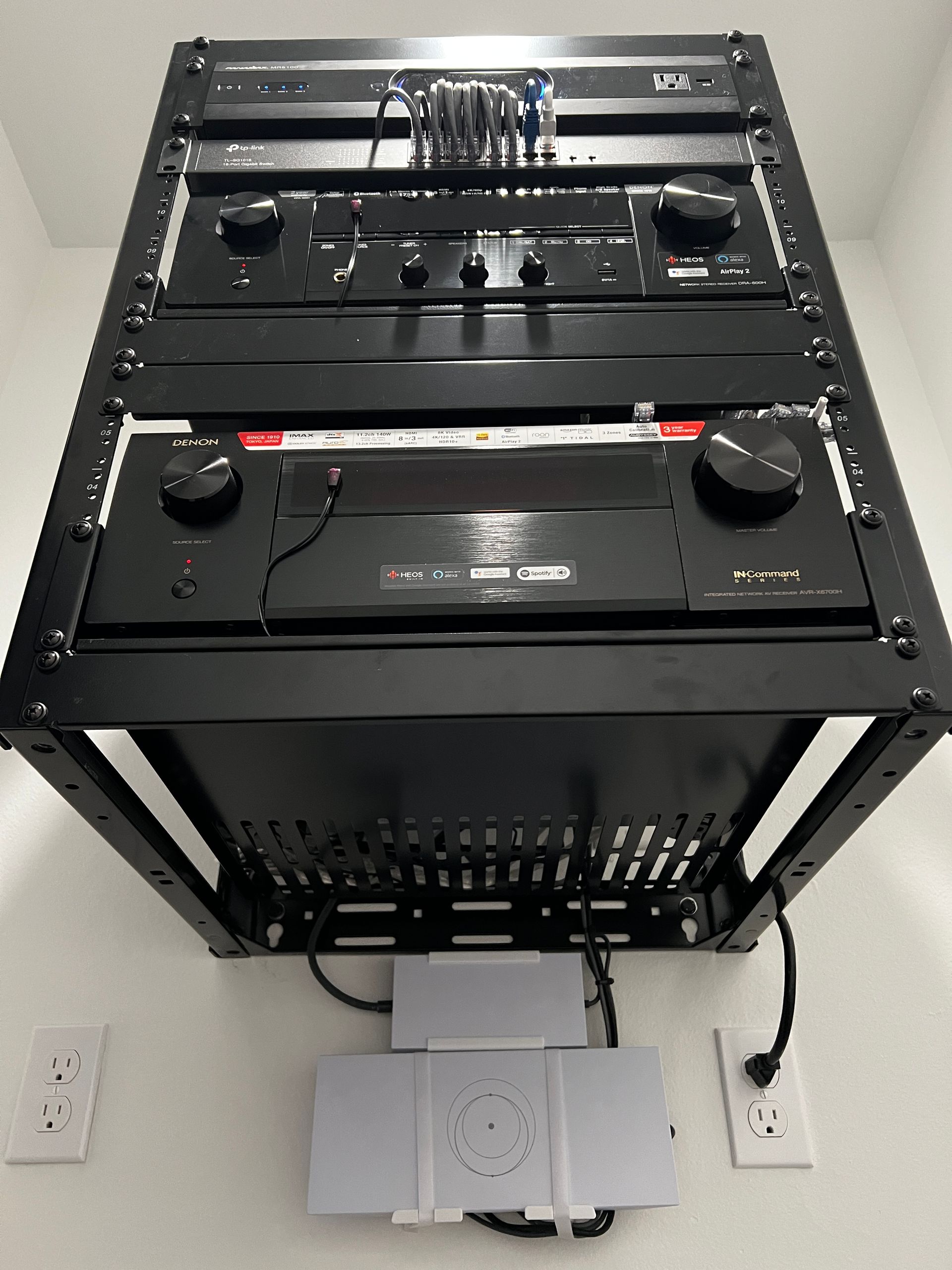 A bunch of electronics are sitting on top of each other on a rack.