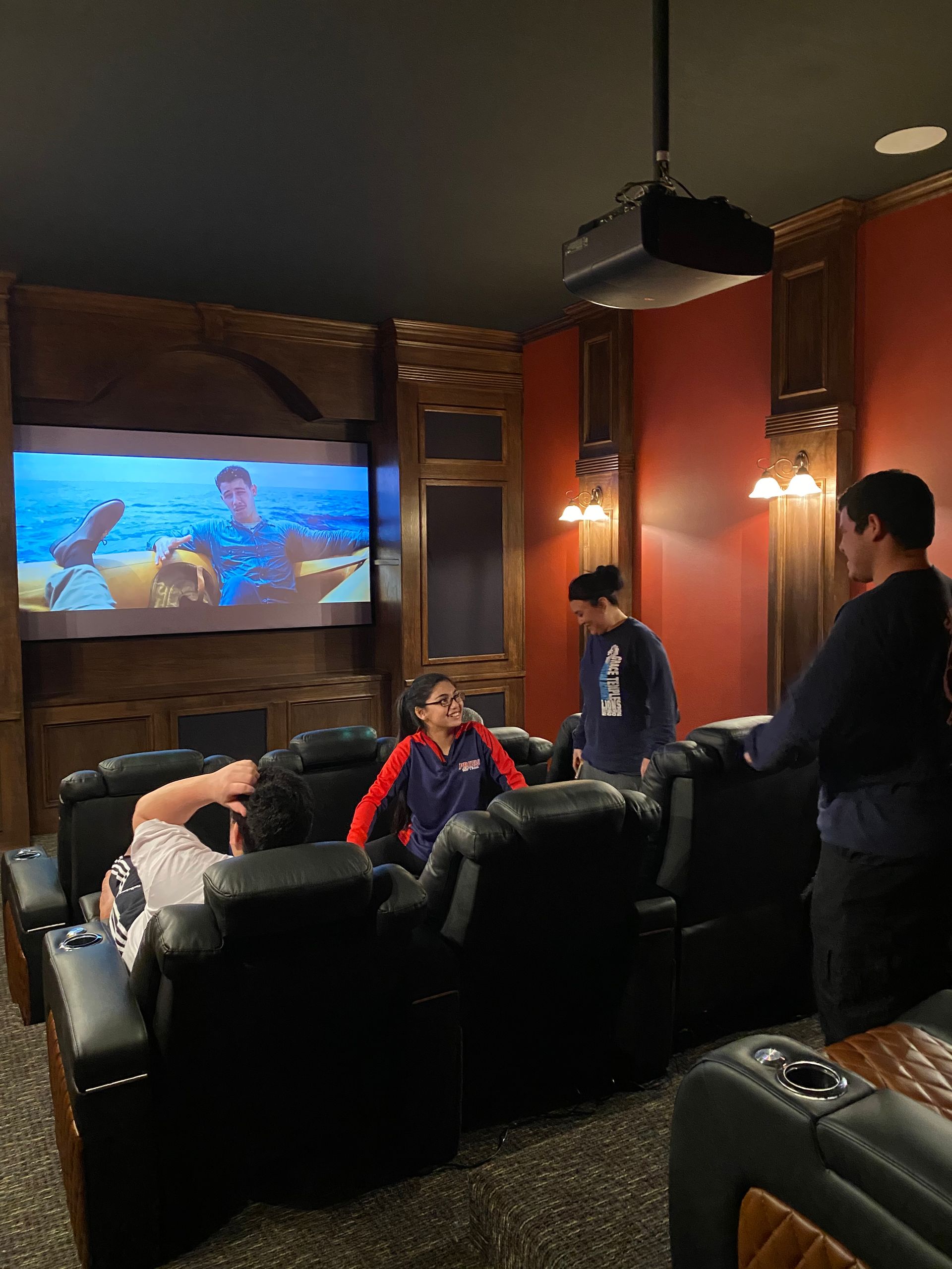 A group of people are sitting in a theater watching a movie.