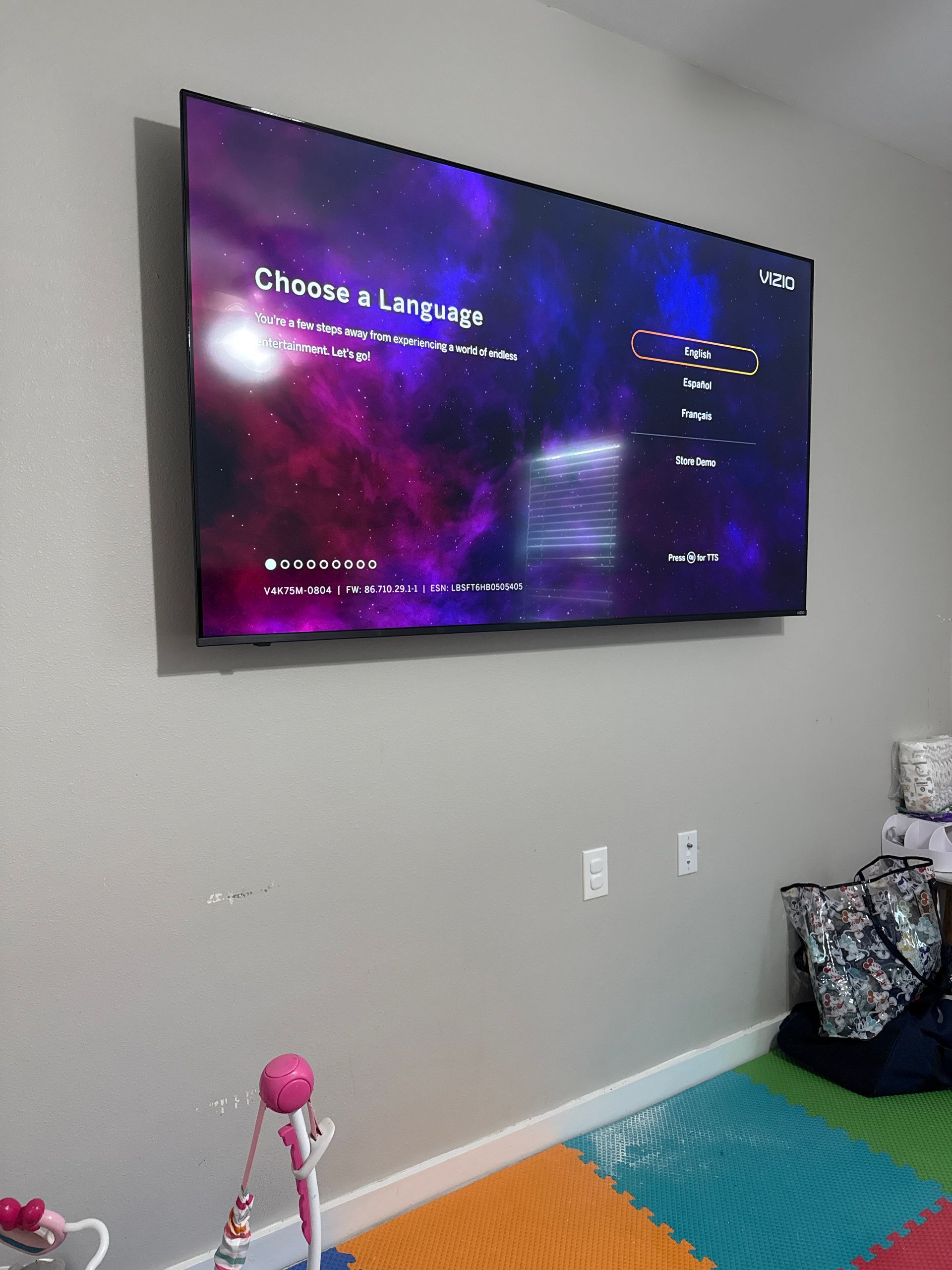 A large flat screen tv is hanging on a wall in a room.