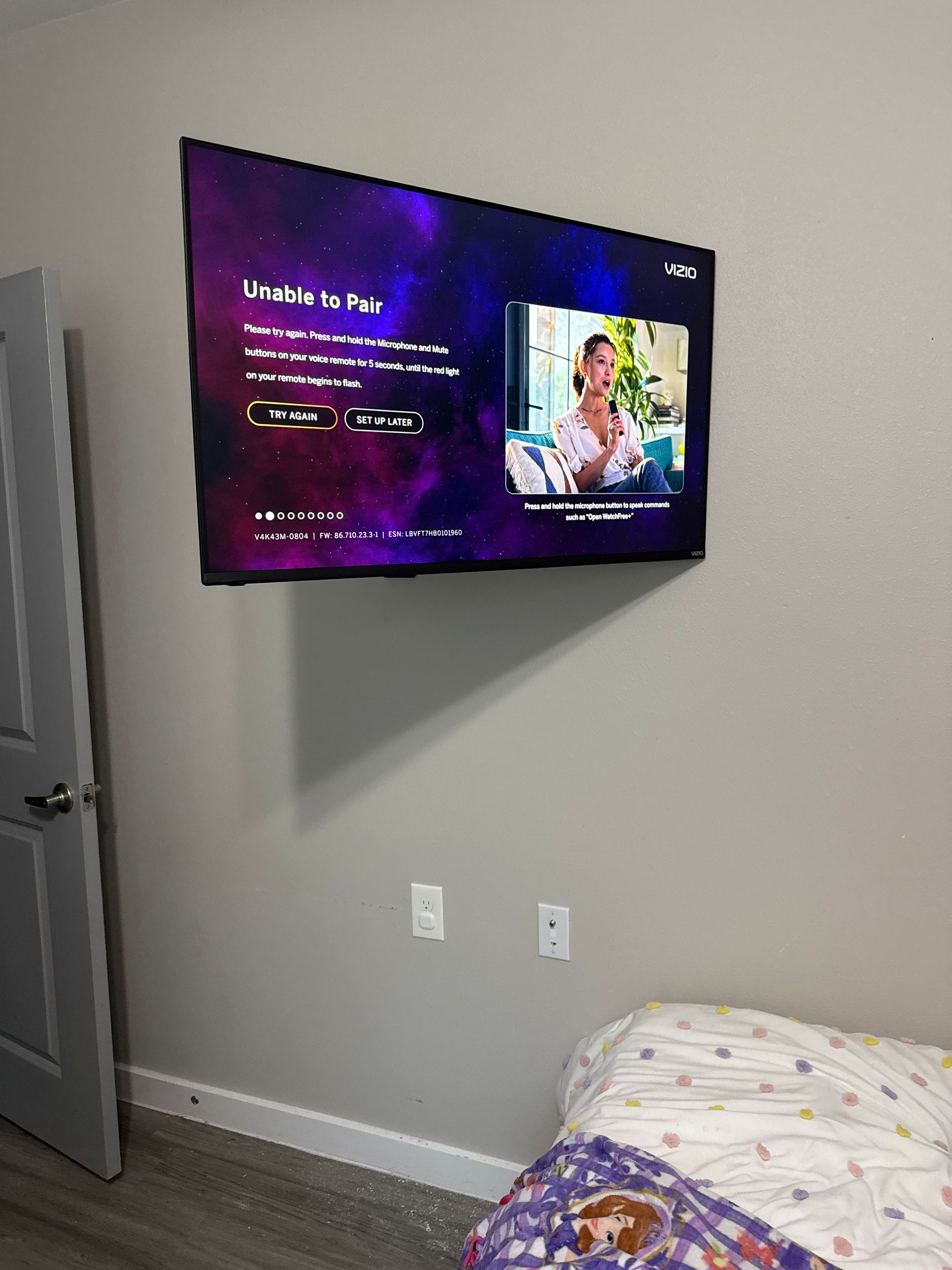 A flat screen tv is mounted on a wall in a bedroom next to a bed.