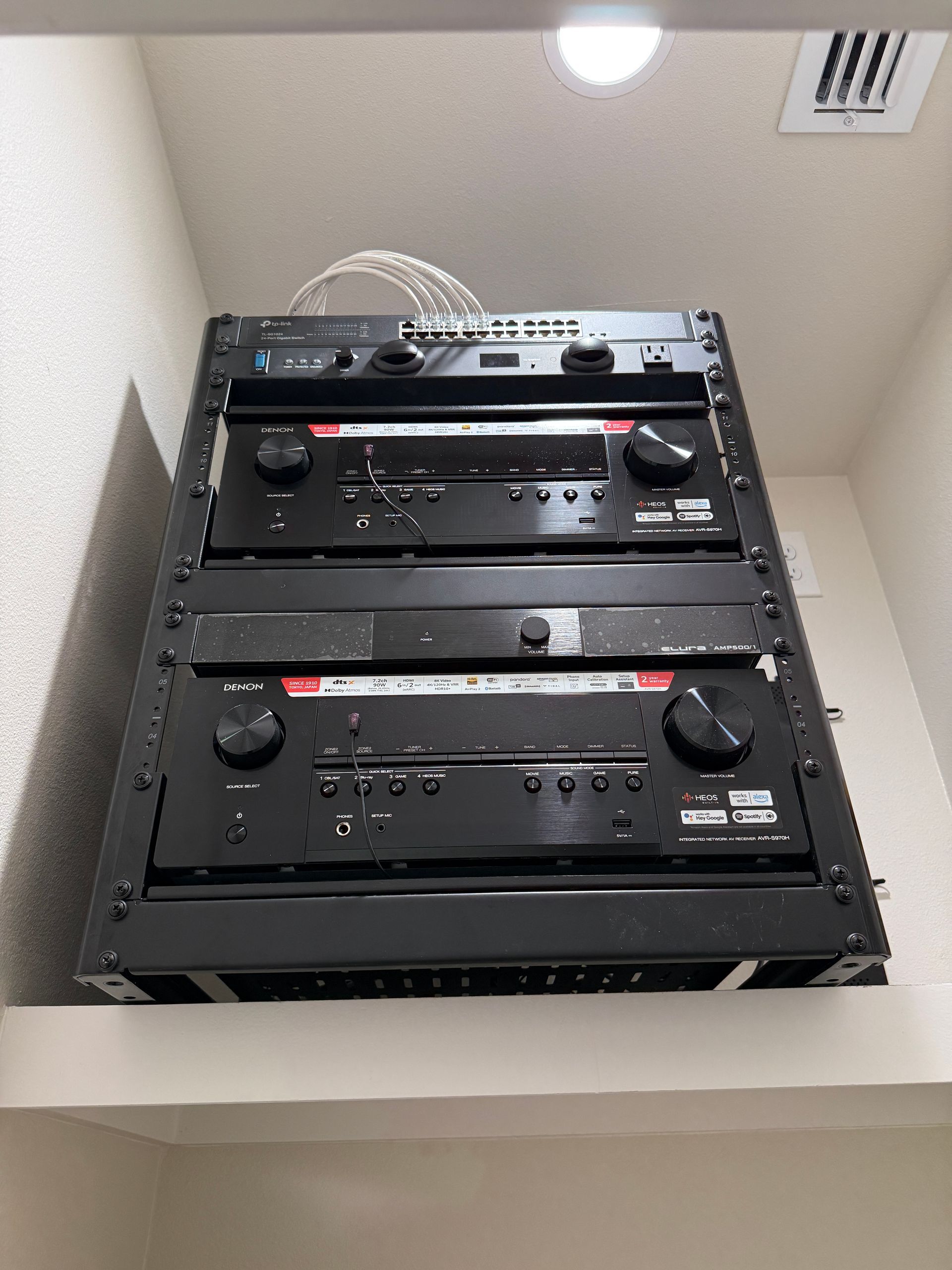 A stack of black boxes sitting on top of each other on a wall.
