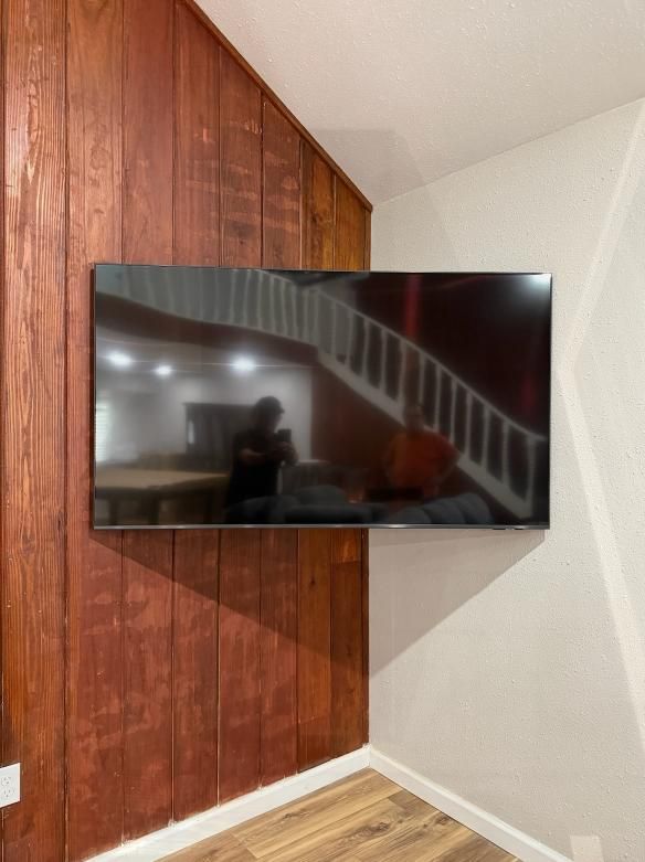 A flat screen tv mounted on a wooden wall
