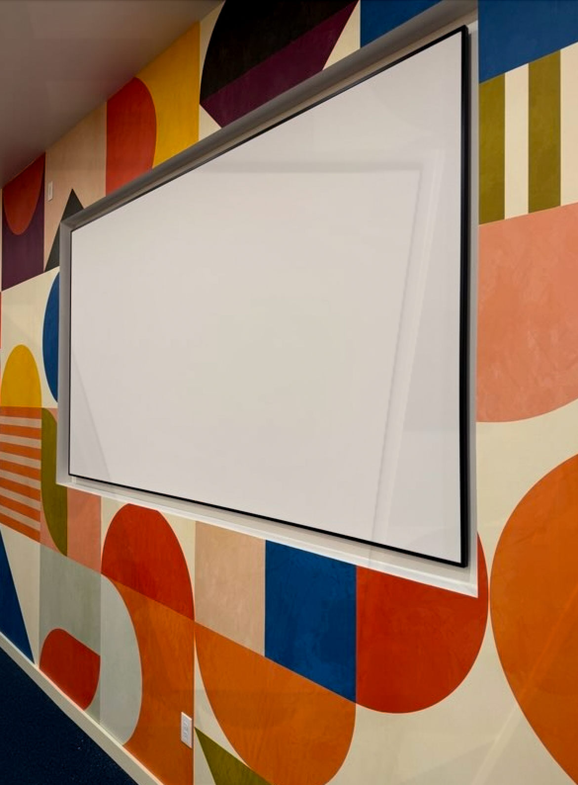 A large white board is hanging on a colorful wall