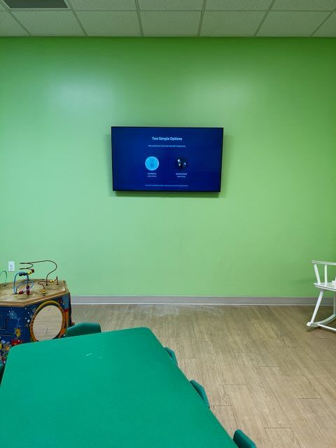 A room with green walls and a tv on the wall