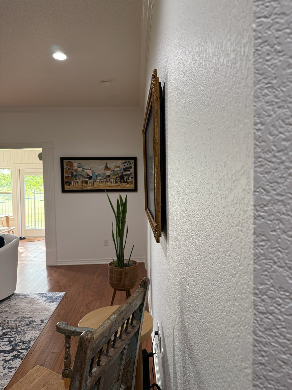 A picture frame is hanging on a white wall in a living room.