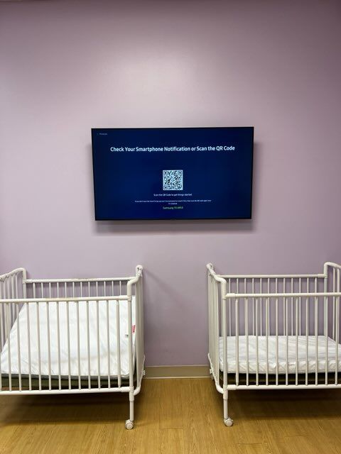 Two baby cribs are sitting next to each other in a room.