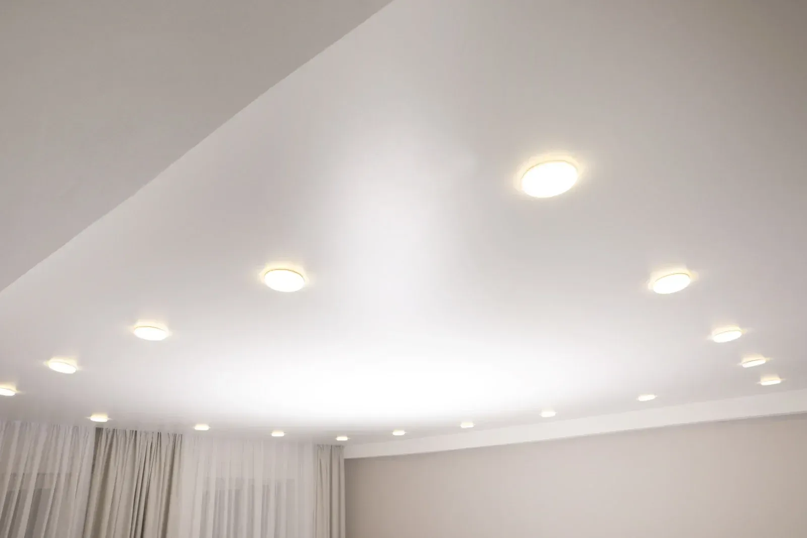 A white ceiling with a lot of lights on it in a room.