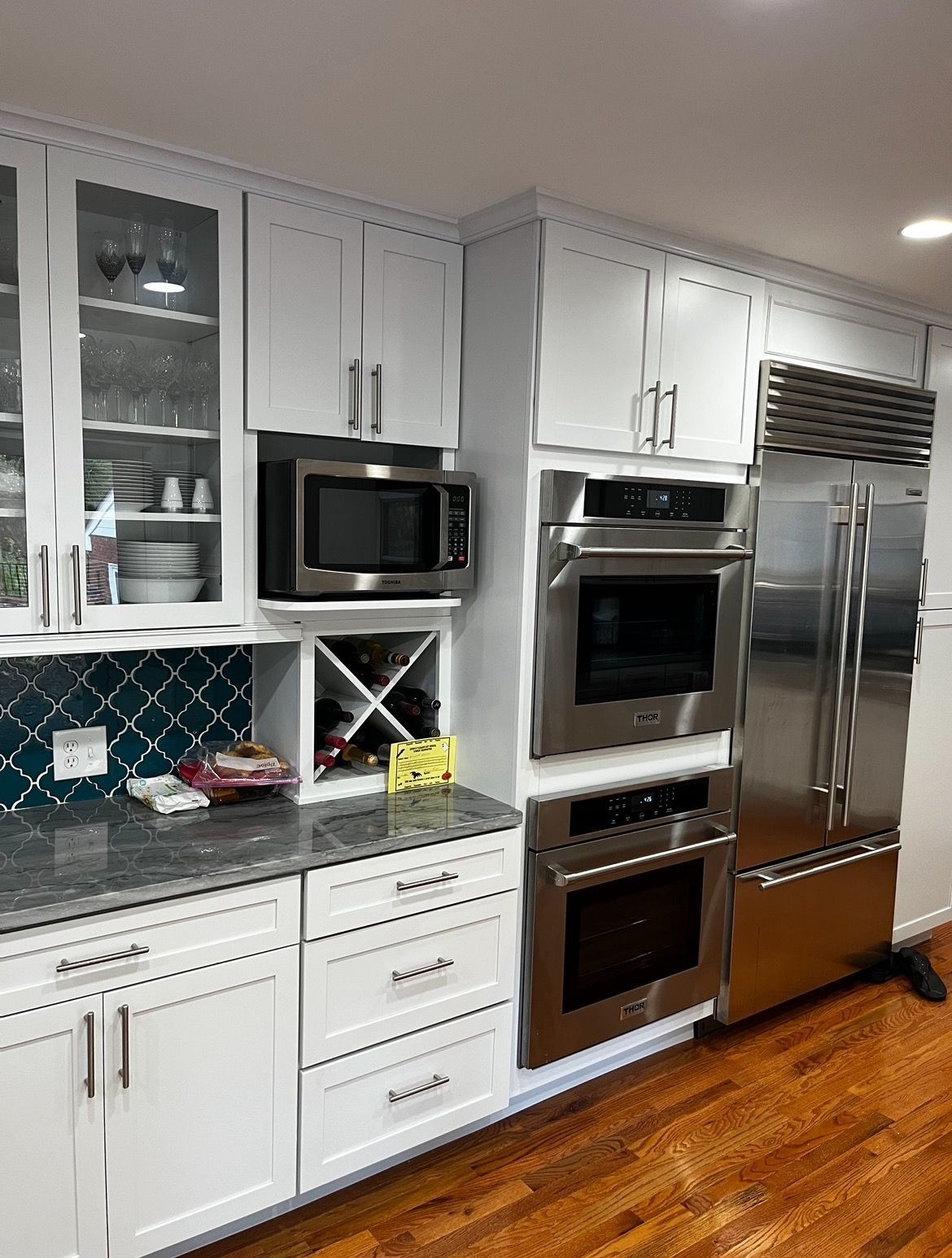 A kitchen with stainless steel appliances and white cabinets