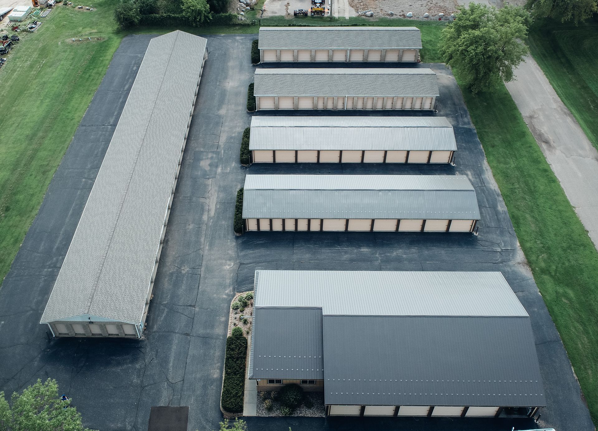 Aerial view of a storage facility with rows of units on a paved lot.