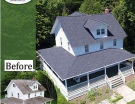 White house with dark gray roof, porch, and a 