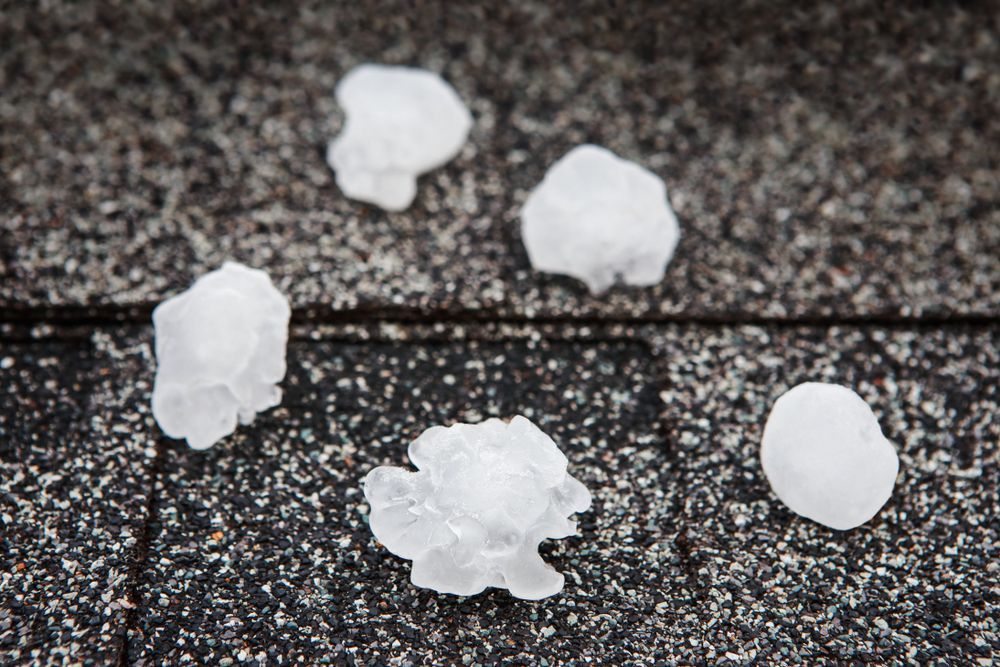 Hailstones on a dark textured surface.
