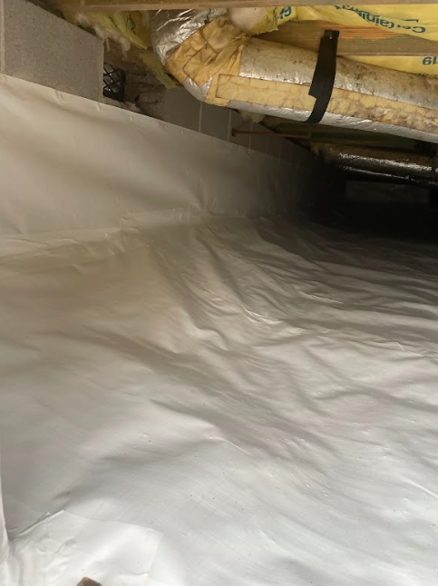A white sheet is covering the floor of a room.