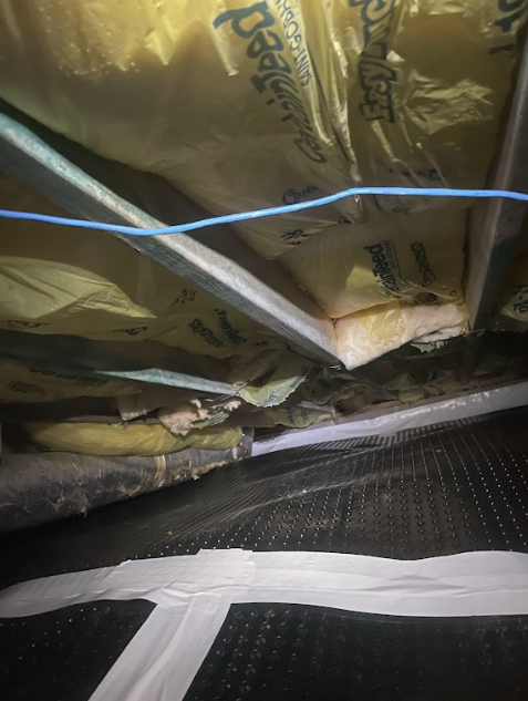 A close up of a ceiling with insulation and wires.