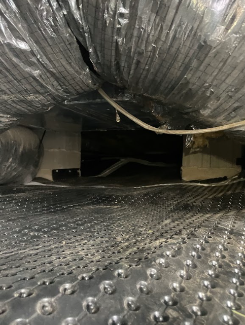A close up of a duct in a basement.