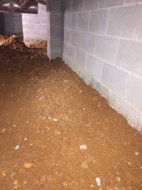 There is a lot of dirt in the corner of the basement.