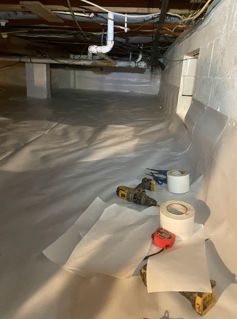 A basement with a lot of duct tape and tools on the floor.