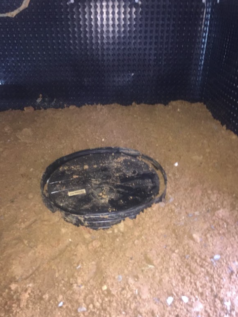 A manhole cover is sitting on top of a pile of dirt.