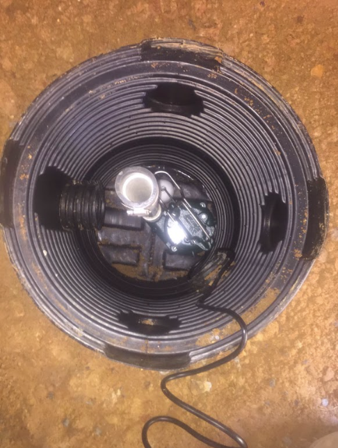 The inside of a bucket with a pump inside of it.