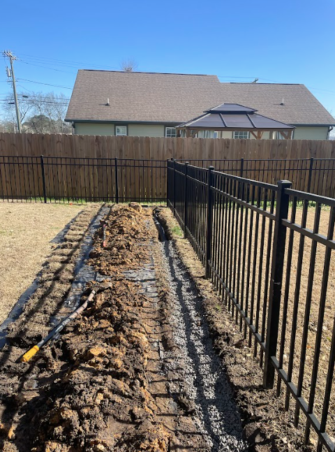 A fence is being built in the backyard of a house.
