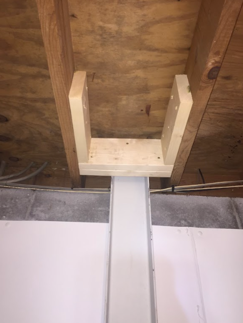 A piece of wood is hanging from the ceiling of a room.