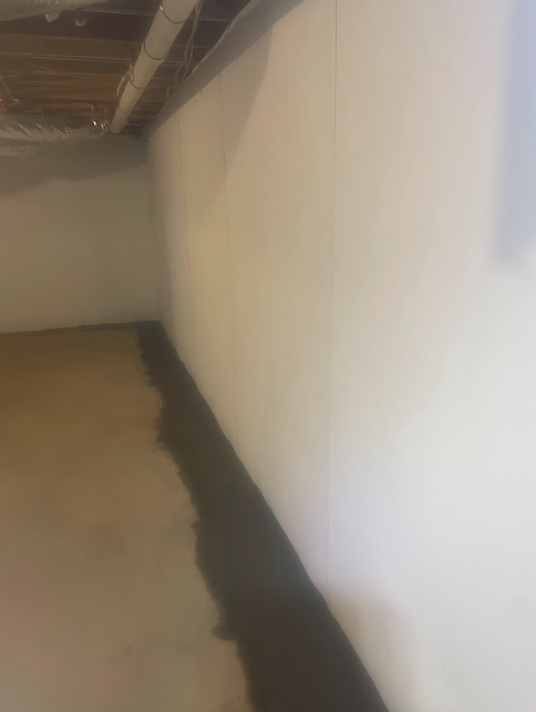 A corner of a room with a white wall and a black border.