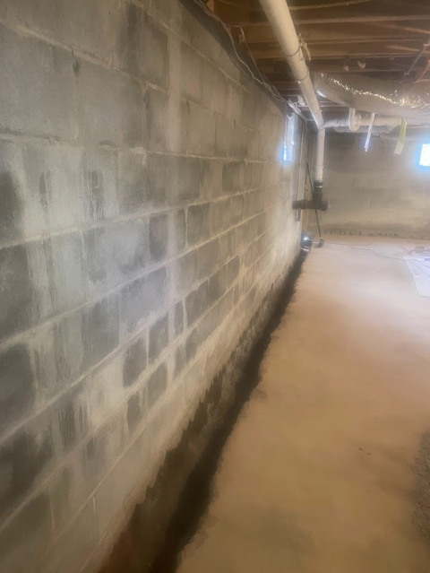 A basement with a brick wall and a concrete floor.