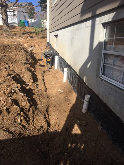 A house is being remodeled with a lot of dirt around it