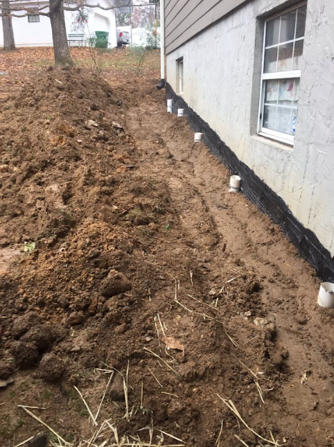 A pile of dirt is sitting in front of a house.