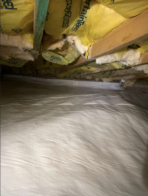 There is a lot of insulation in the ceiling of a room.