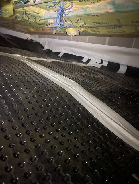 A close up of a drainage system in a basement.