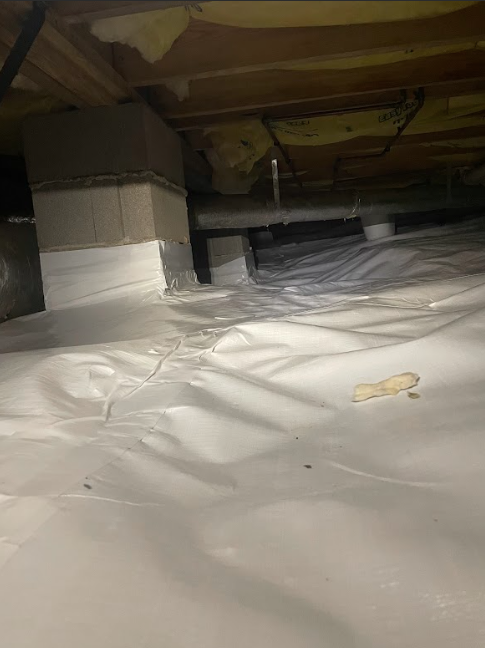 A basement with a lot of white plastic on the floor.