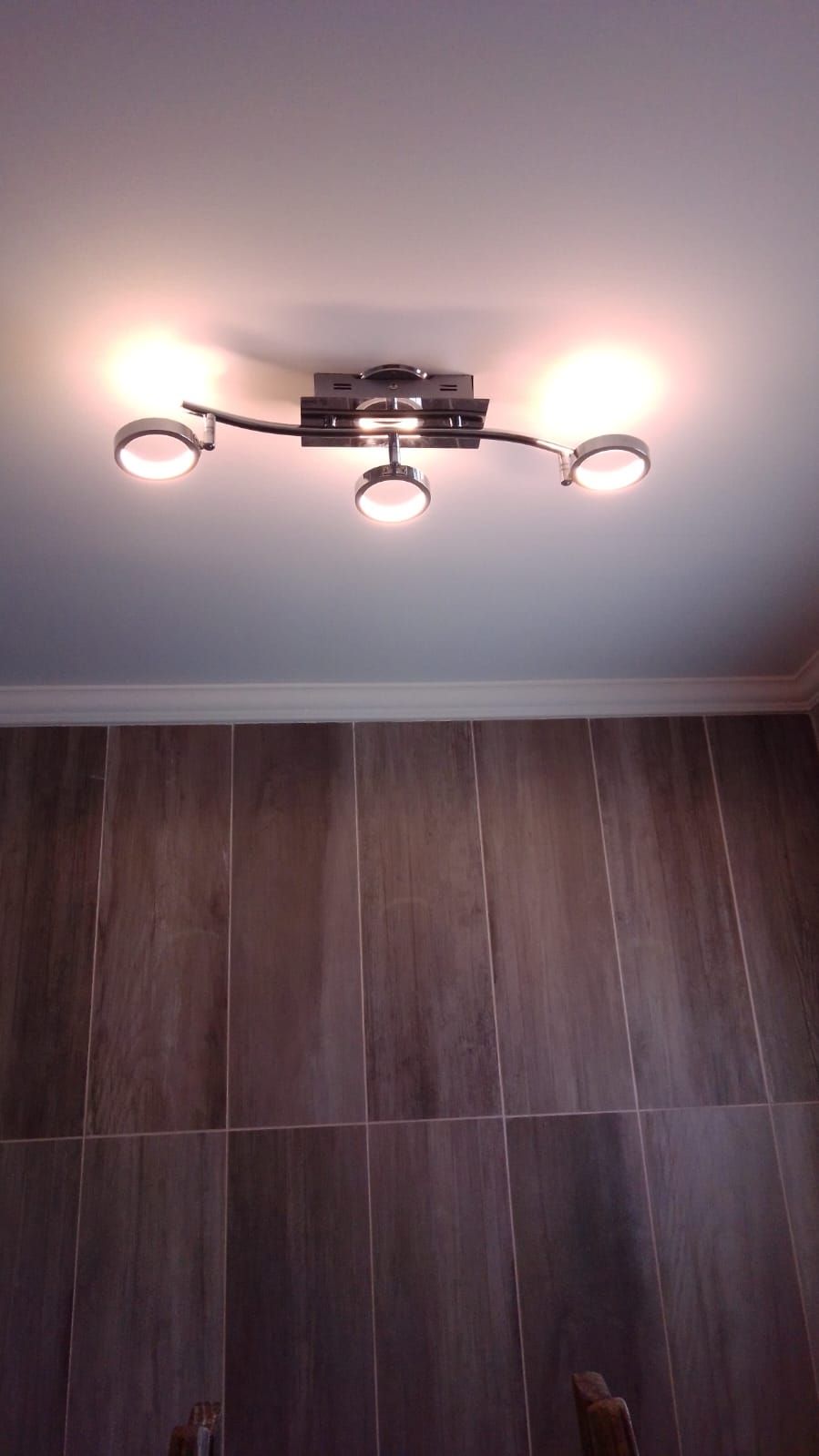 Una lámpara de techo cuelga del techo de un baño.