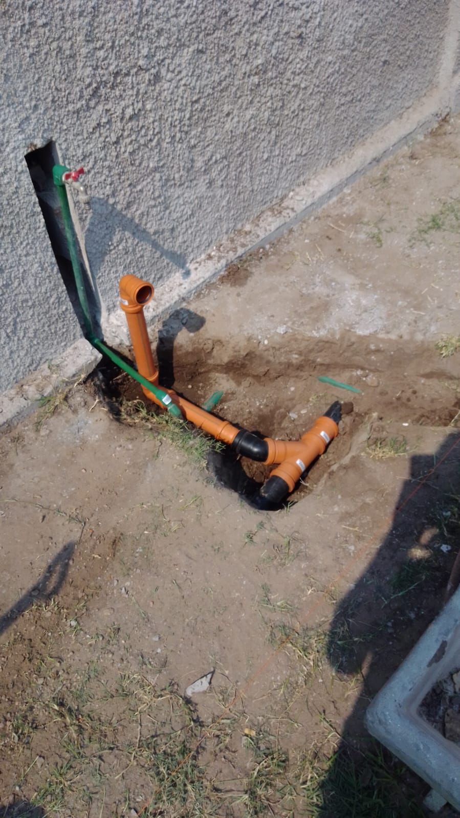 Un montón de tubos están tirados en el suelo junto a una pared.