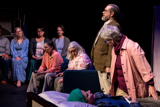 a photograph of audience members watching actors on a stage