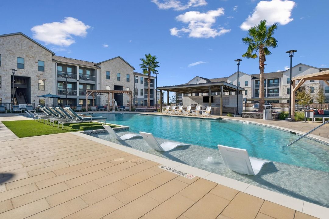There is a large swimming pool in front of a building.
