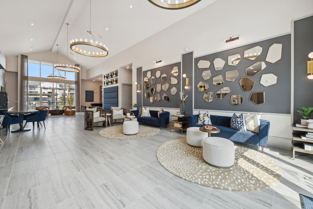 A large living room with a lot of furniture and mirrors on the wall.
