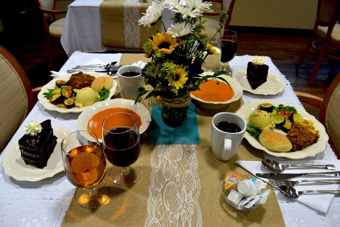 A table topped with plates of food and a vase of flowers.