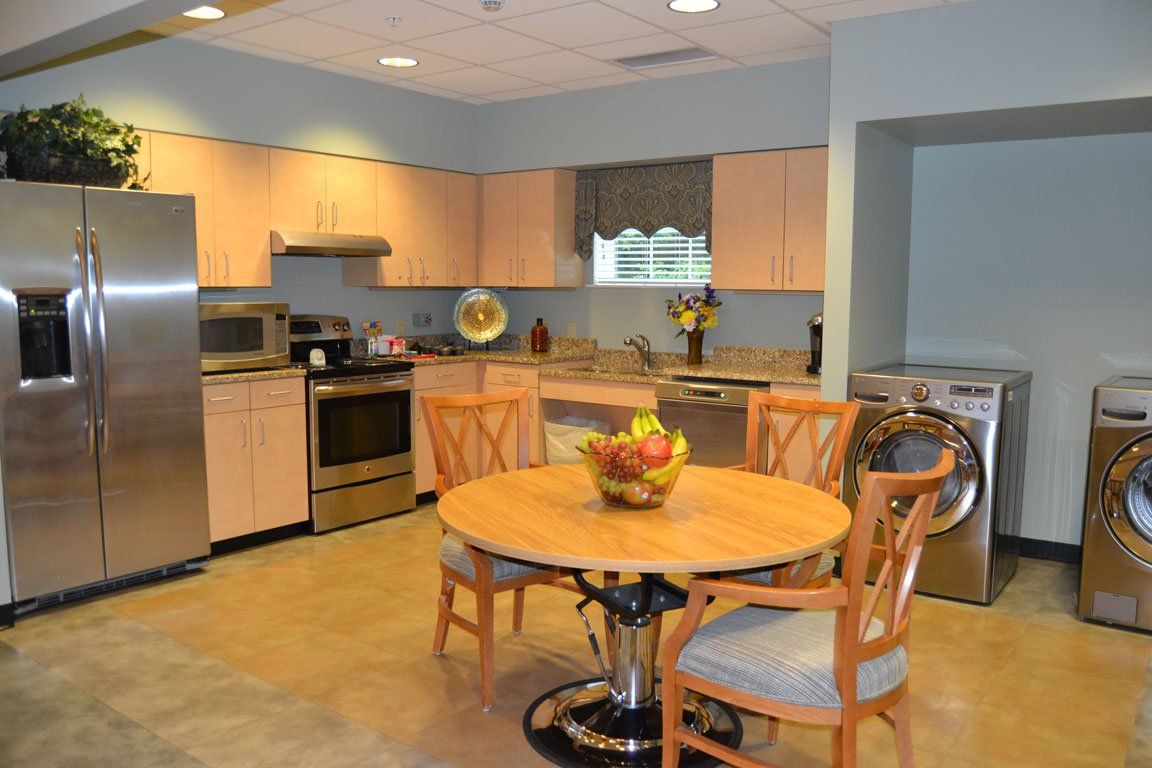 A kitchen with a table and chairs and a washer and dryer