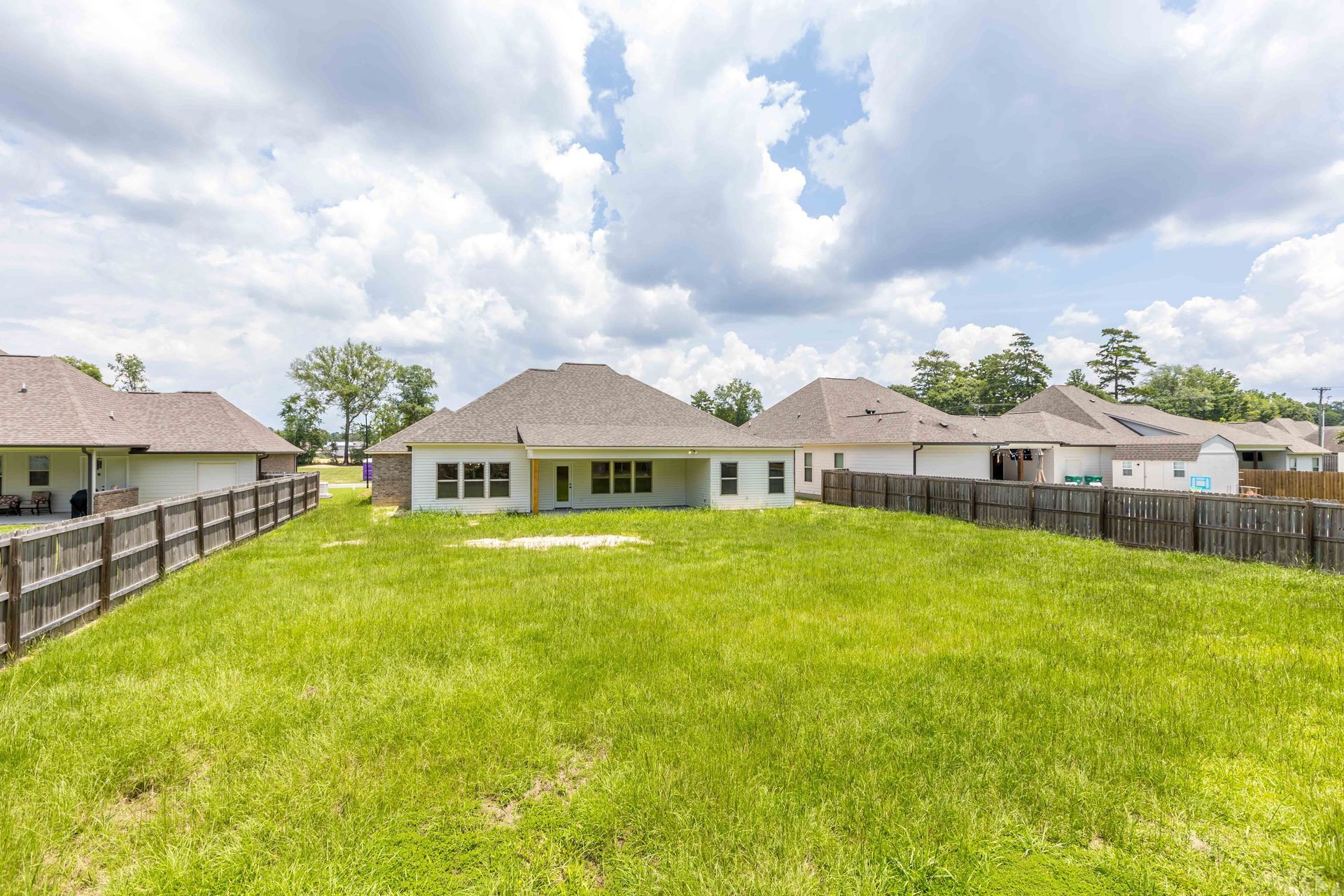 Young boy smiles with a raised finger, looking at a laptop with a Christmas tree background.