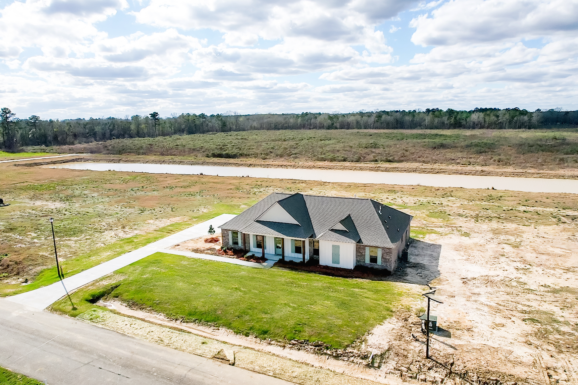 Young boy smiles with a raised finger, looking at a laptop with a Christmas tree background.