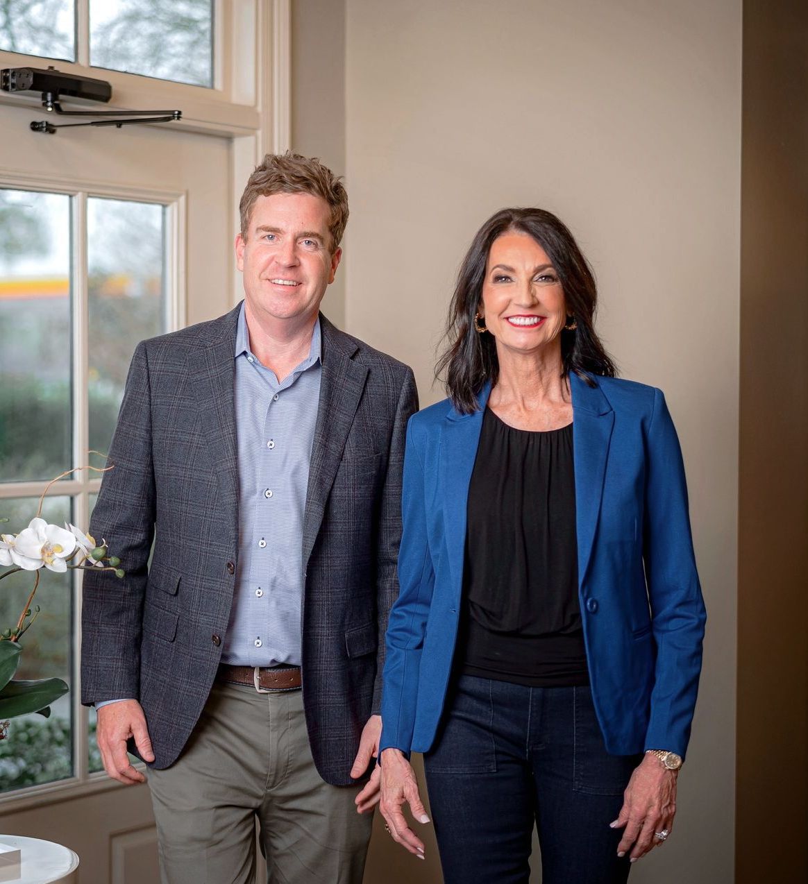 Young boy smiles with a raised finger, looking at a laptop with a Christmas tree background.