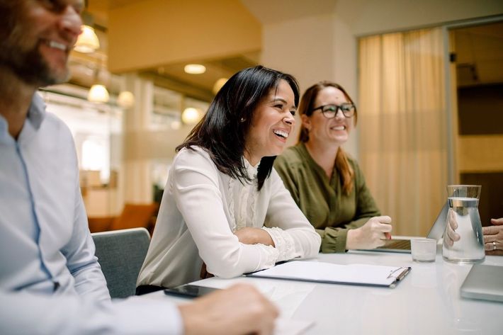 A group of people are sitting at a table having a meeting.