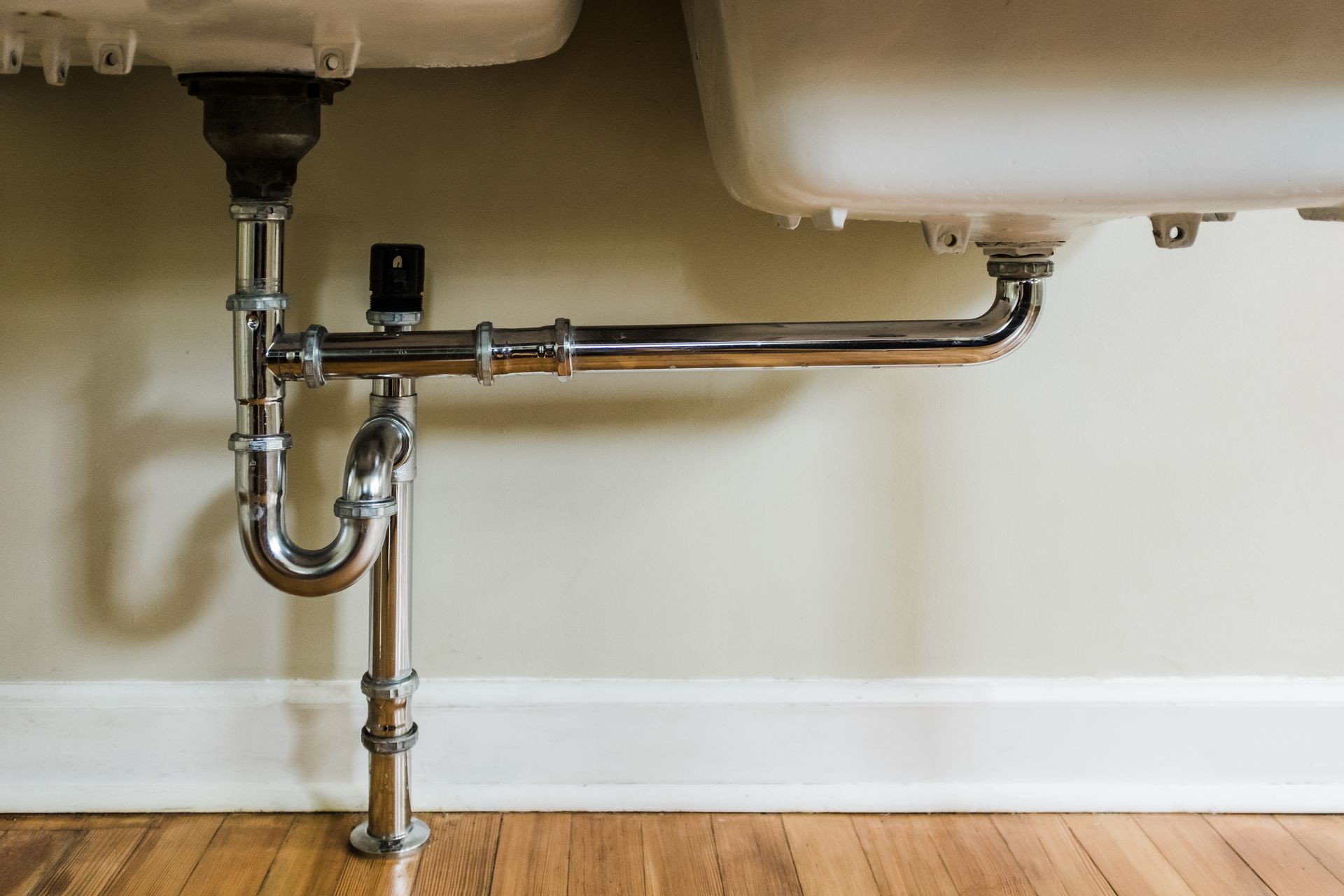 Close-up of water pipes under sink.