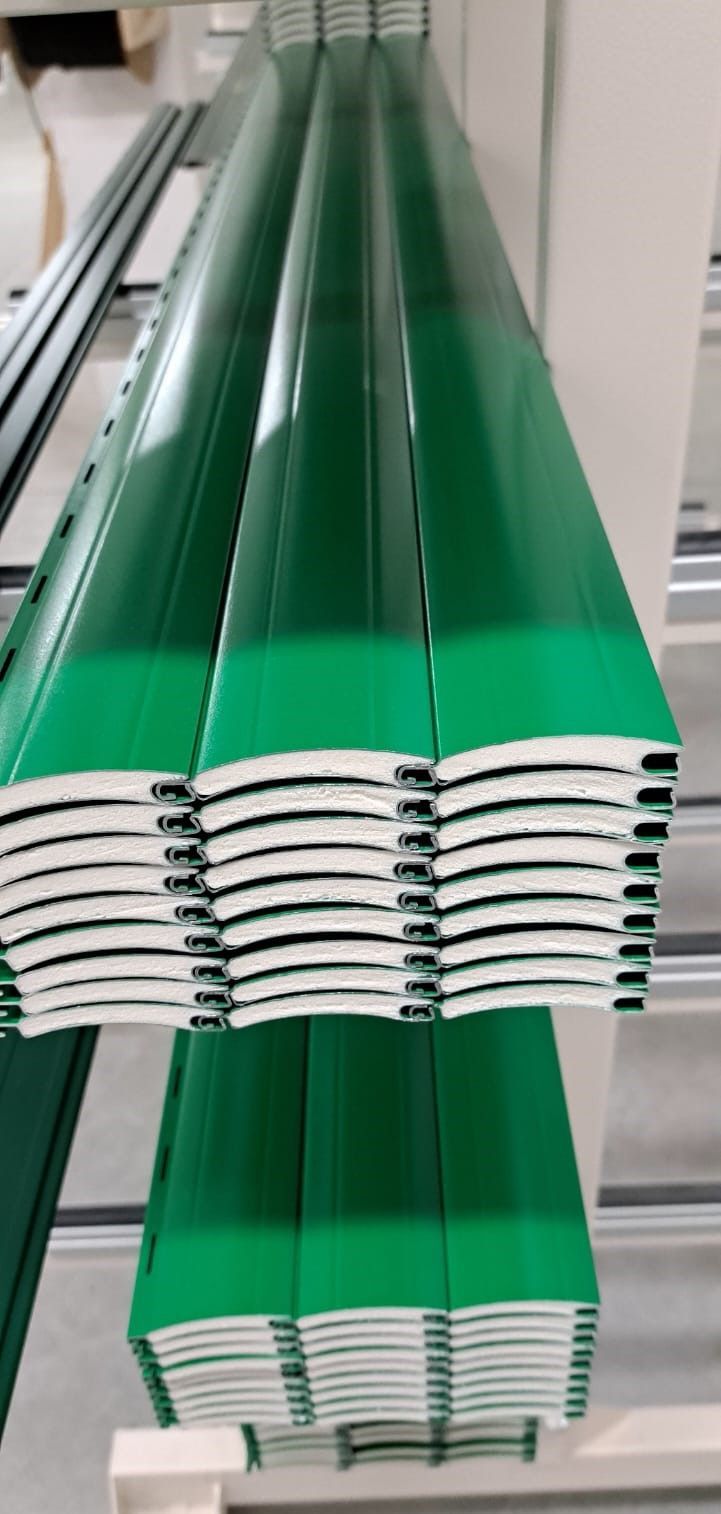 Una pila di fogli di metallo verde appoggiati uno sopra l'altro su un tavolo.