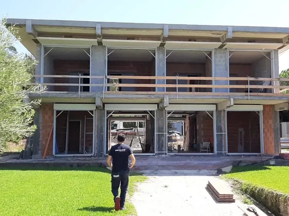 Un uomo è in piedi davanti a un edificio in costruzione.