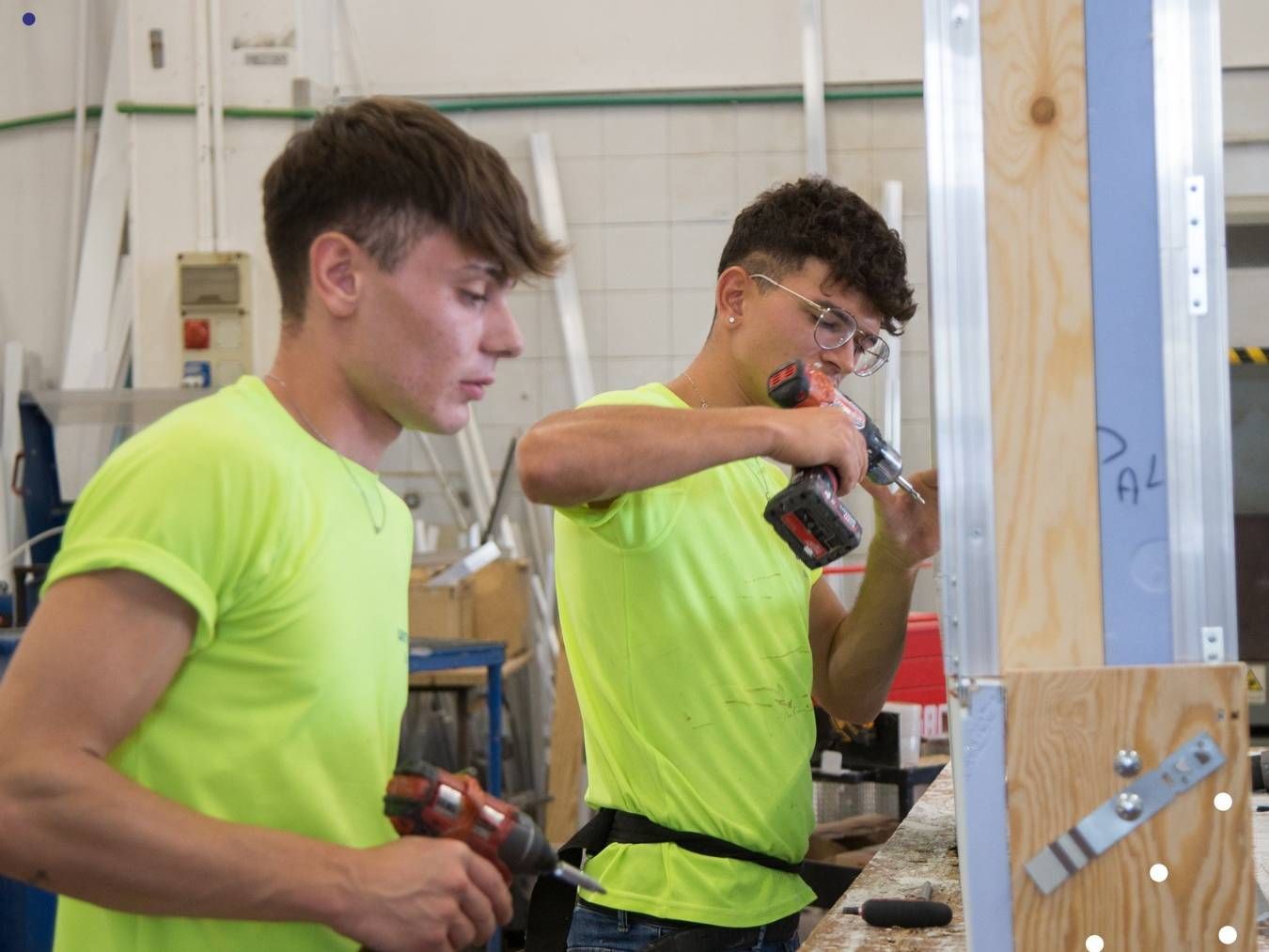 Due giovani stanno lavorando su un pezzo di legno in una fabbrica.