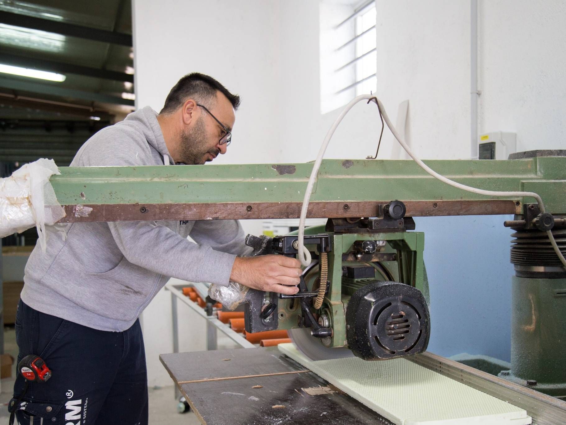 Un uomo sta lavorando a una macchina in una fabbrica.