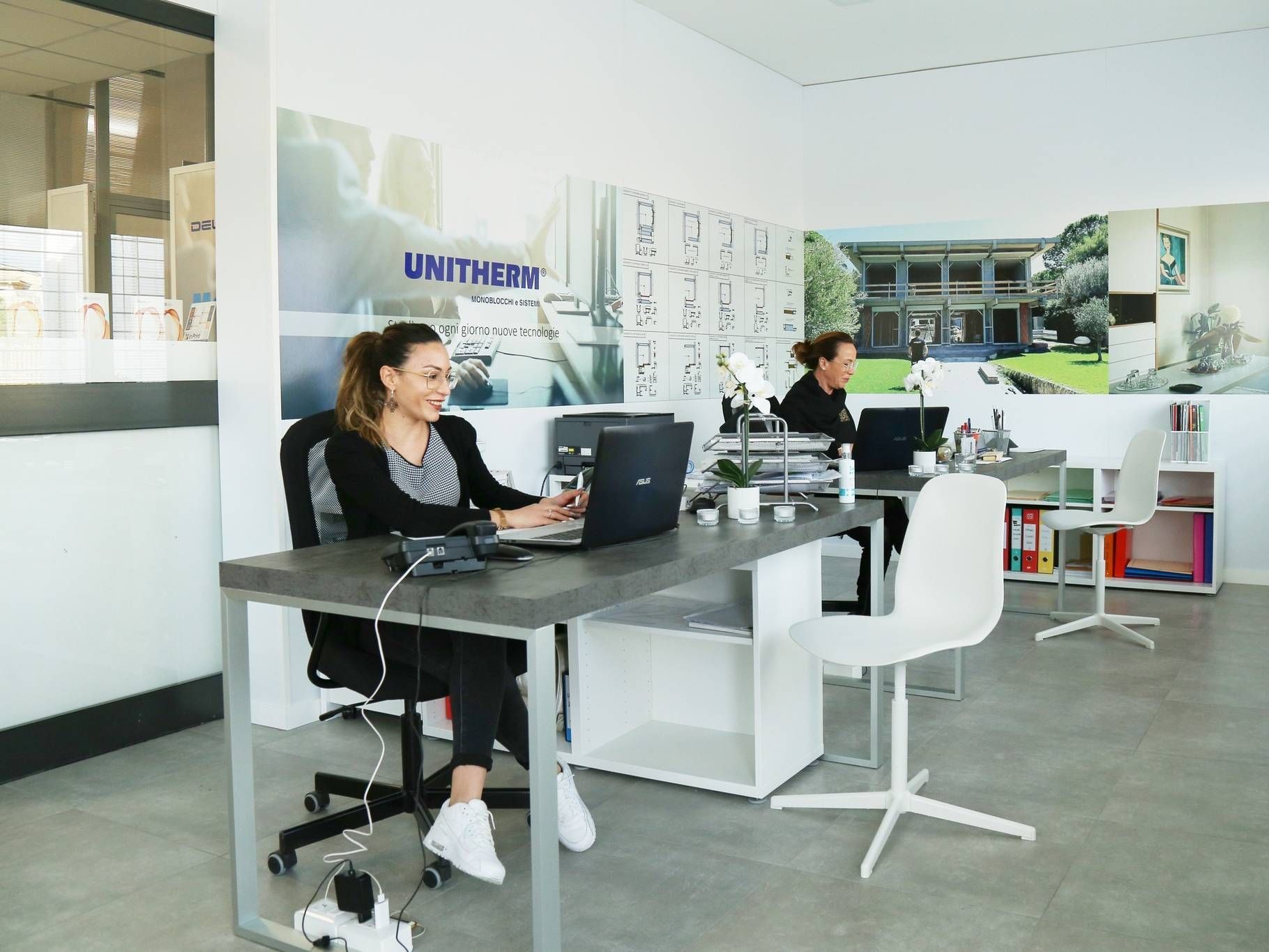 Una donna è seduta alla scrivania e usa un computer portatile.