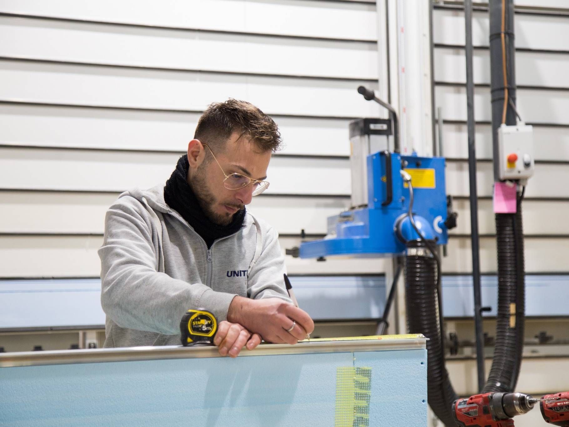 Un uomo sta lavorando su un pezzo di legno in una fabbrica.